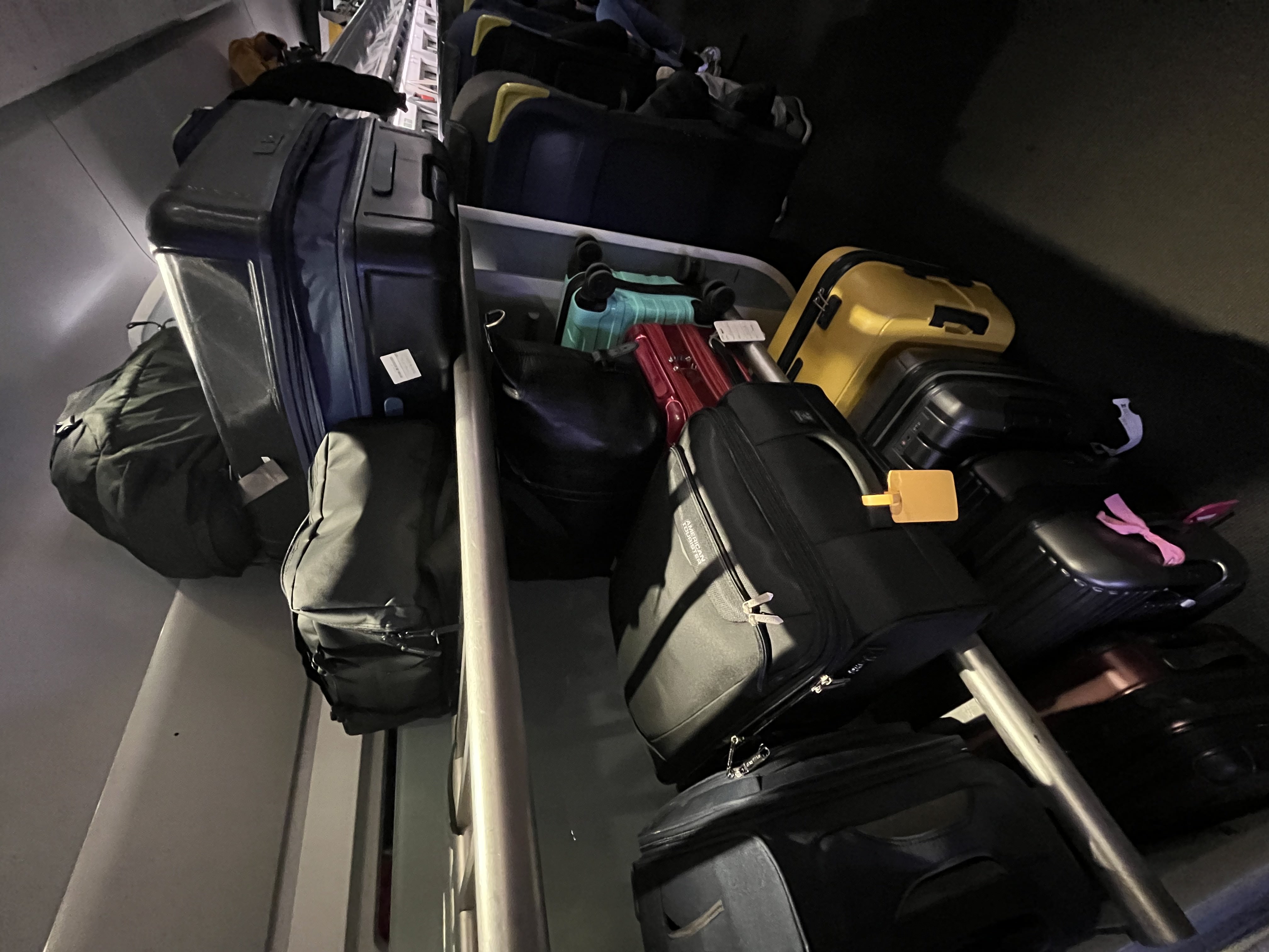 Suitcases and wheelie bags stacked on a luggage rack on board a train