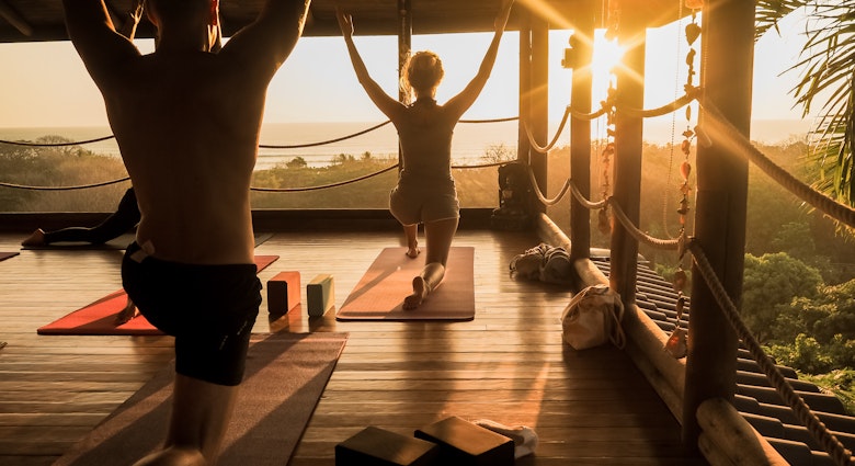 People practice yoga in an open yoga studio near the ocean while the sun sets..
1074578957
adult, balance, beautiful, blind, class, contemporary, costa rica, doing, exercise, female, fitness, group, hall, happy, healthy, hut, jungle, large, lifestyle, light, meditate, meditation, nature, open, outside, palm tree, peace, people, person, pose, position, relaxation, retreat, silhouette, sky, space, sport, studio, style, summer, sunlight, sunset, tropical, vacation, view, wellness, woman, wood, wooden, yoga