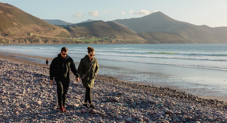 Ireland coastline with view of the ocean and mountains, man and woman walking through Ireland wind
Ireland coastline with view of the ocean and mountains, man and woman walking through Ireland wind